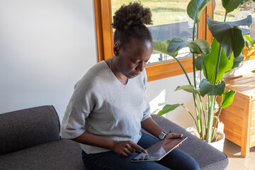 reading email, woman using internet on digital tablet at home
