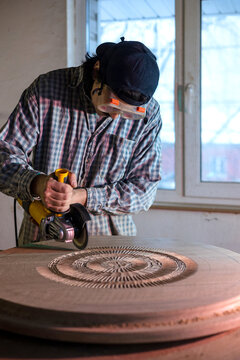 Artisan Carefully Carving Wood in a Workshop 