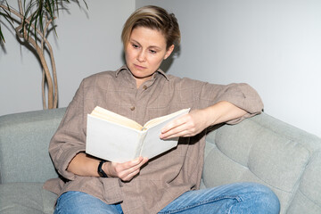 Woman reading a book on a sofa