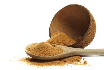 Coconut palm sugar pile in wooden spoon with fruit shell, isolated on white background, side view