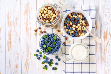 Healthy breakfast with  corn balls and chocolate corn balls and blueberry on a white wooden table, top view.