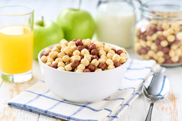 Healthy breakfast with corn balls with two flavors and fruits and juice on a white wooden table, selective focus.