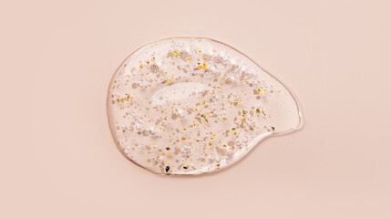 Serum fluid 24k gold gel facial cream smear, on beige pastel background. Beauty cosmetic product smudge, pure transparent lotion with gold particles, skin care jelly serum, top view Luxury moisturizer