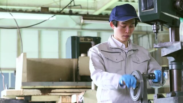 ハンドドリルで部品を加工する男性