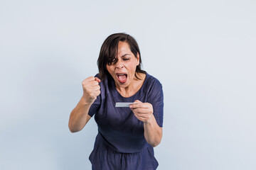 portrait of adult latina woman holding a card in blank on blue background in Mexico Latin America, or hispanic senior brunette female 
