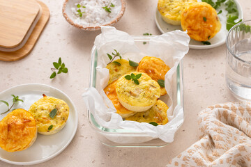 Egg bites with ham and cheese, and chicken and pesto in a meal prep container, high protein snack idea