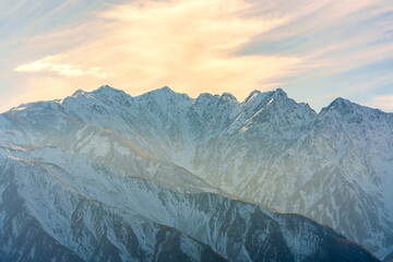 Beautiful winter mountain scenery with sunlight illuminating the peaks in Hakuba, Nagano Prefecture, Japan,