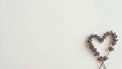 A delicate lavender heart shaped arrangement on a soft, serene white background