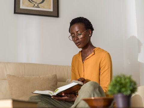 Intelligent woman studying in living room 
