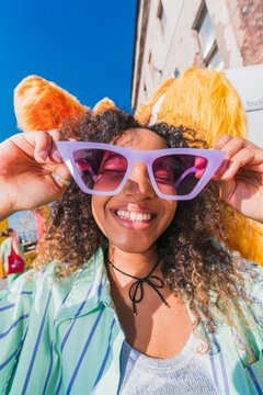 Cheerful young woman smiling in purple sunglasses