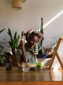 Smiling woman combing hair 