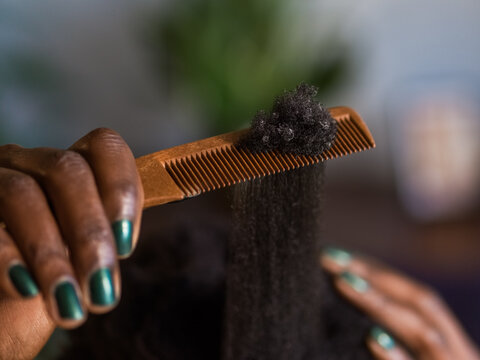 Woman combing kinky hair 