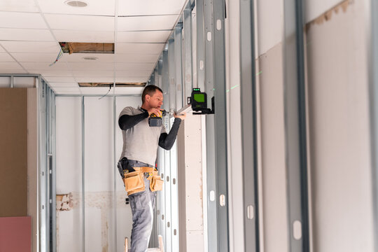 Drywaller making framing using laser level