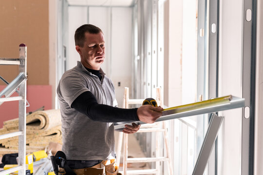 Drywaller measuring framing 