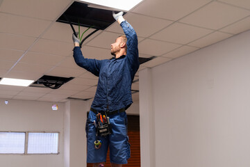 Electrician checking ceiling wiring