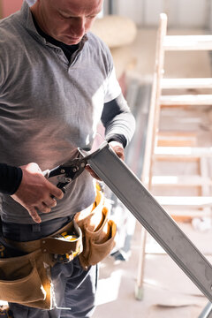 Man cutting metal framing at construction site