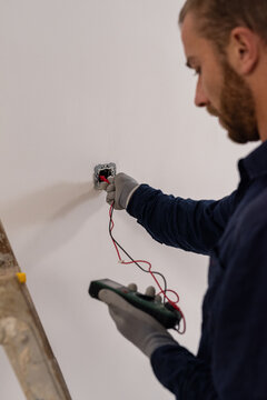Electrician checking wiring with multimeter