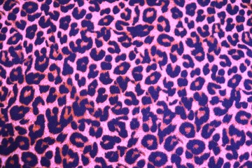 Knitted wool pattern with a leopard design. Fabric and textile with leopard pattern and in purple, pink and black. Textured background for paper or different kind of pattern.