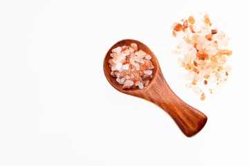 Himalayan pink salt crystals on a wooden spoon against a white background