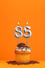 Number 85 candle - Birthday card design in orange background. Cupcake