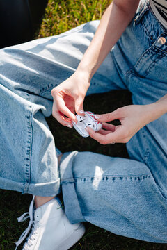 Girl's hands closeup taking out wireless earbuds outdoor