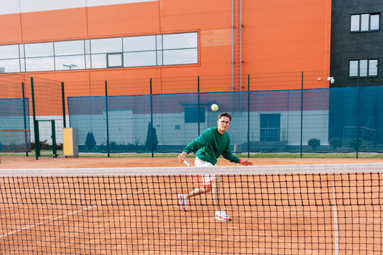 Tennis player enjoys a match on a clay court in a sports club