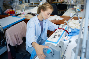 Seamstress expertly managing fabric through industrial sewing process