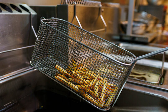 Freshly cooked fries cooling in a basket at a Restaurant Kitchen