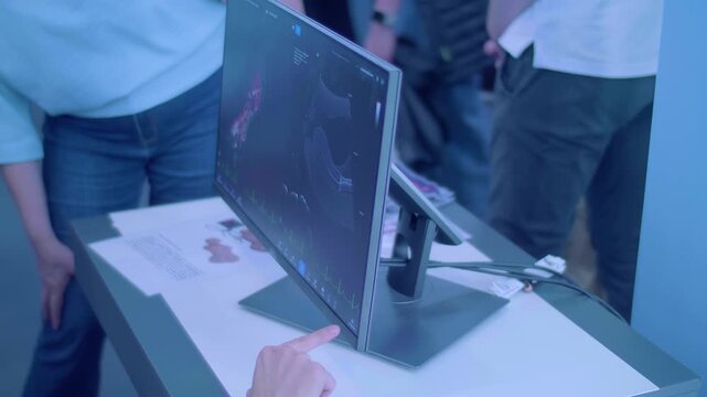 A little girl is learning the profession of a doctor on a simulator &ndash; ultrasound examination of the abdominal cavity with a result image displayed on the monitor. Closeup 