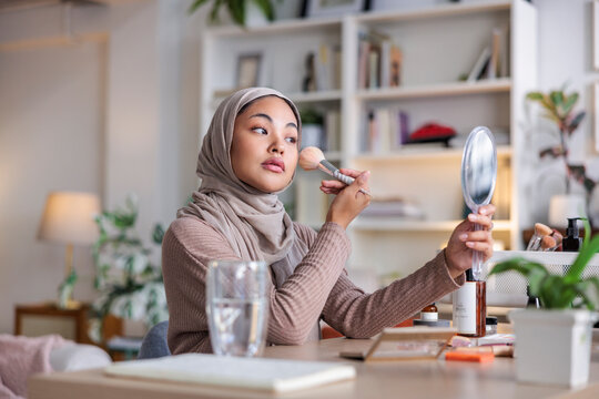 Muslim woman touching up makeup before a meeting