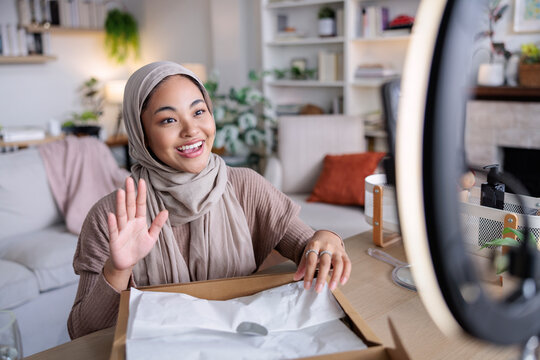 Influencer waves during unboxing video.