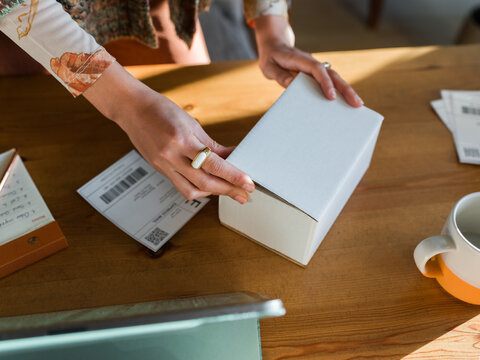 Woman closing box with goods 