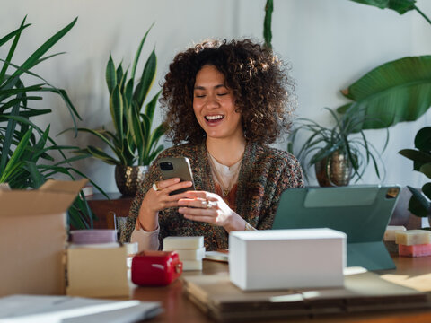 Happy woman laughing while reading text message