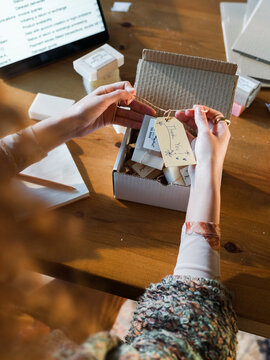Woman attaching greeting label to goods 