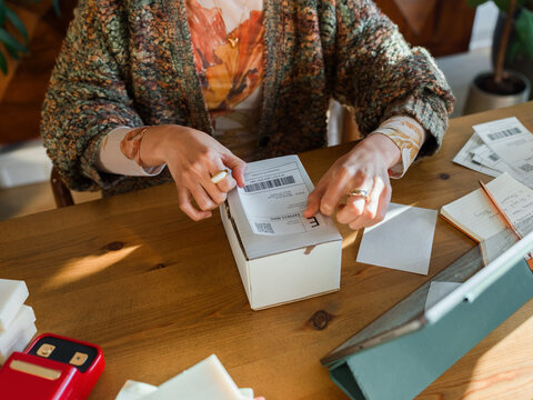 Woman applying shipping label 