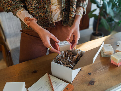 Woman packing handmade soap in box