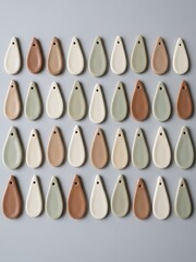 Teardrop shaped ceramic pieces organized on a neutral surface background