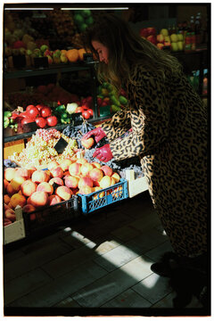 Young woman buying fresh organic groceries at farmer's market.