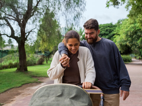 Couple interacting with baby in stroller