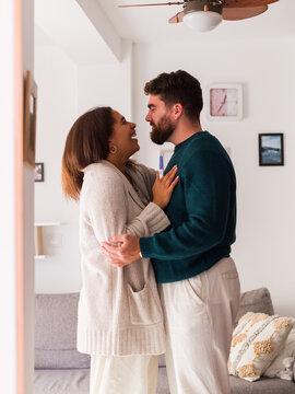 Excited couple sharing moment of joy after positive pregnancy test
