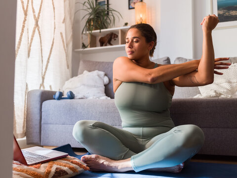Woman watching online yoga tutorial