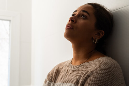 Contemplative Woman Standing Against a Wall in Bathroom