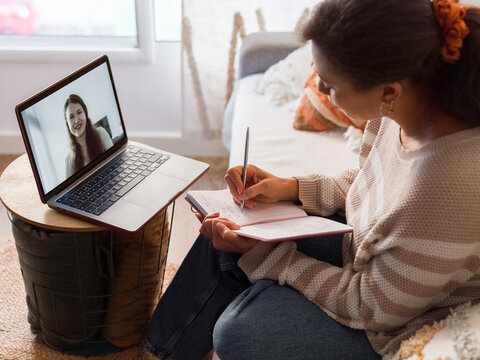 Woman taking notes during video call