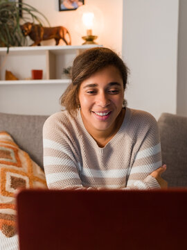 Smiling woman watching video on laptop