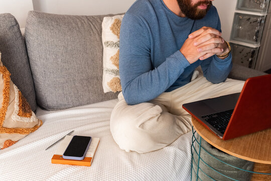 Man thinking while working on laptop 