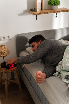 Man Waking Early in the Morning in a Cozy Bedroom