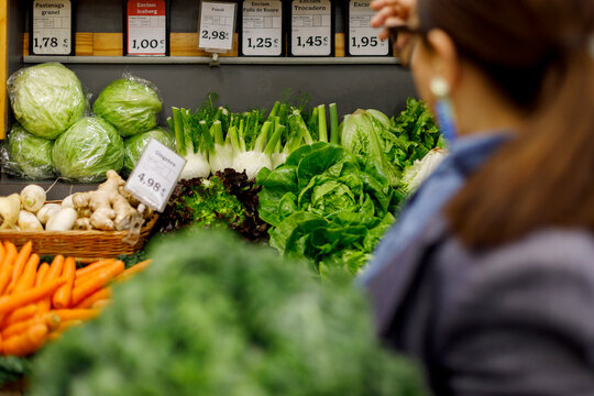 Woman Shops for Lettuce and Fresh Produce at Grocery Store