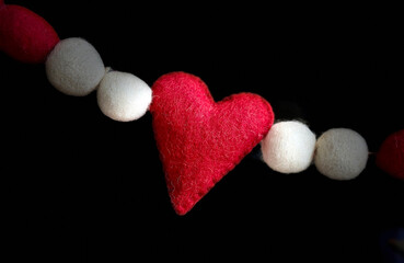 Red heart and spheres made of felt on a string