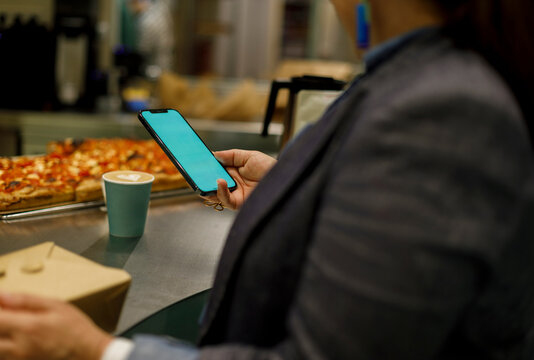 Person Checks Phone While Sitting at a Restaurant