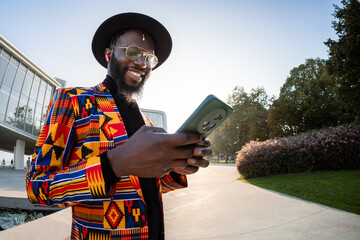 Man in African fashion using smartphone